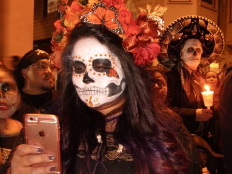 Jeune fille avec téléphone Apple et maquillage de Noche de los Muertos