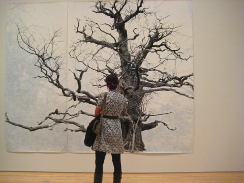 Photo : une dame devant le tableau d'un arbre en hiver
